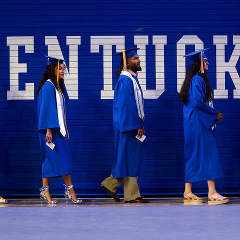 photo of students walking in caps and gowns
