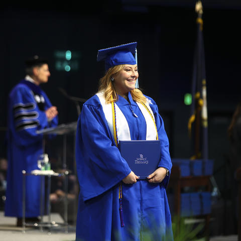 Marilyn Simpson standing with her diploma at Commencement. 