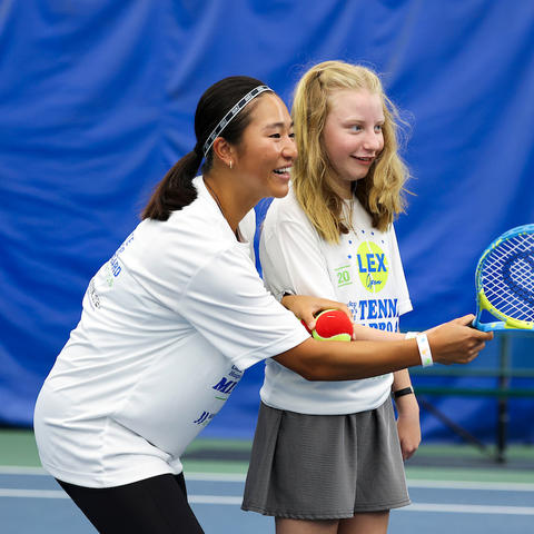 Image of a little girl learning how to play tennis