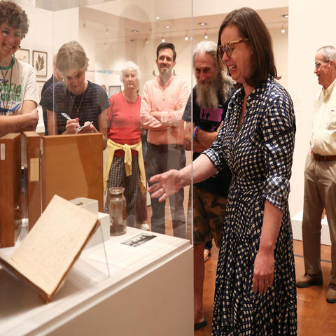 Group tours museum exhibit during gallery discussion.