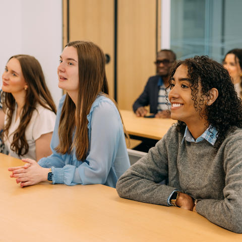 A group of students sit at desks in a classroom