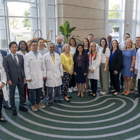 Group photo of approximately 20 members of the University of Kentucky Gill Heart & Vascular Institute Ventricular Assist Device team, including physicians, nurses and staff, standing together in the hospital lobby.