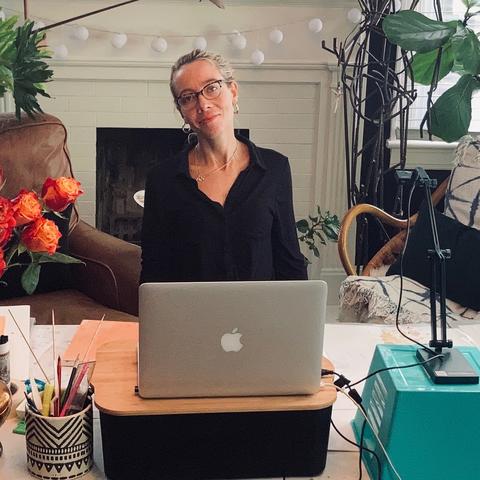 photo of Aubrey Nibert seated in her studio with laptop to teach GSA visual art online