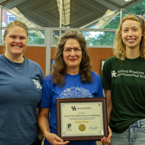 three people holding a certificate 