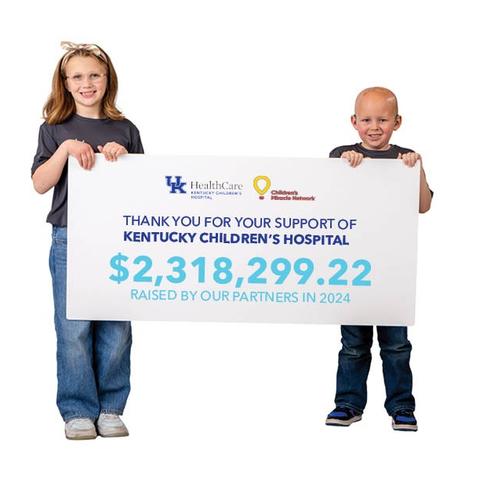 Image of two children holding a sign announcing the more than $2 million dollars raised for KCH