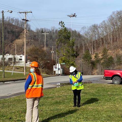 Kentucky Homeplace community health workers Chyna Smith, left, and Carole Frazier retrieve a package delivery from a drone.