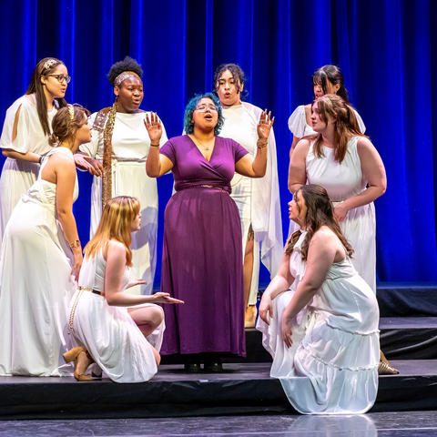 Eight singers surrounding a soloist on stage