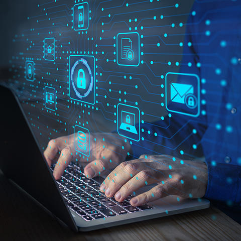 Man at keyboard with floating icons depicting locks and security