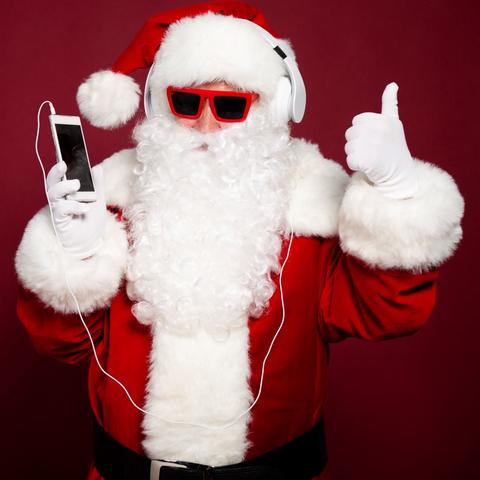 stock photo of Santa in sunglasses listening to an ipod giving a thumbs up
