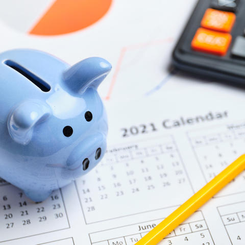 blue piggy bank, calendar and calculator with pencil