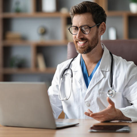 Doctor teleconferences with a patient via laptop
