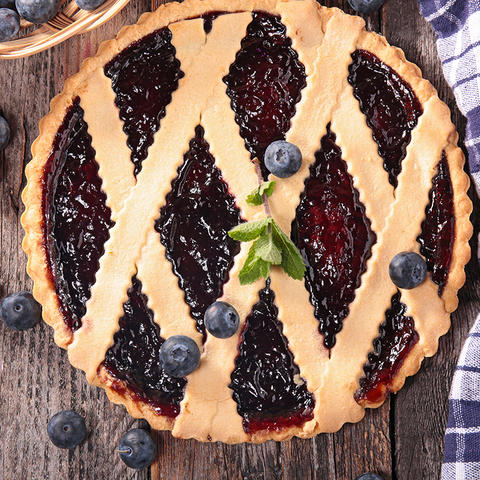 photo of blueberry pie with blueberries on top and to side