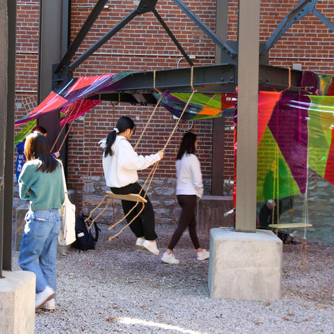 Knitted pillows and swinging elements invite viewers to pause, reflect and engage with the installation’s immersive atmosphere. Photo by Haley Simpkins. 
