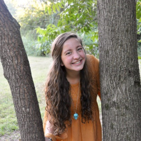 photo of Hannah Thomas posing by tree