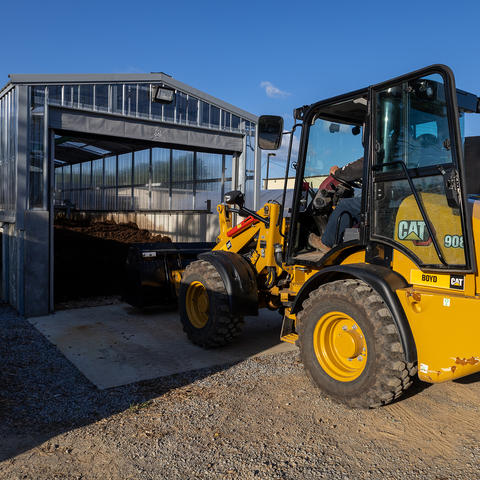 A composting building with a piece of machinery. 
