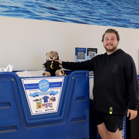 A student with a Give and Go donation bin. 