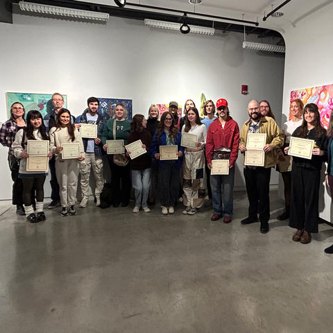 Students lined up displaying awards
