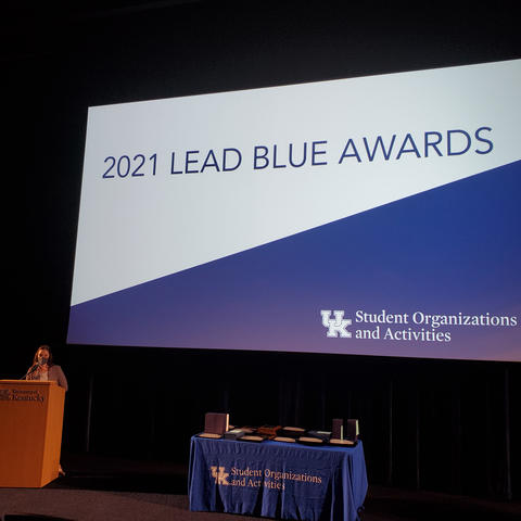 Screen in auditorium reading "2021 Lead Blue Awards" against white and blue background