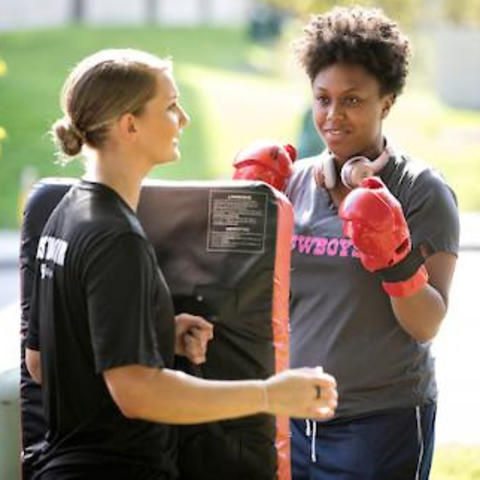 a photo of an officer training someone in self defense