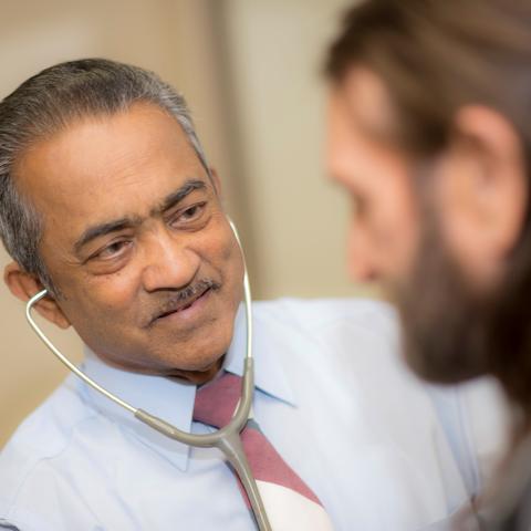 photo of Dr. Roy Varghese with a patient