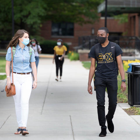 students with masks walking on campus