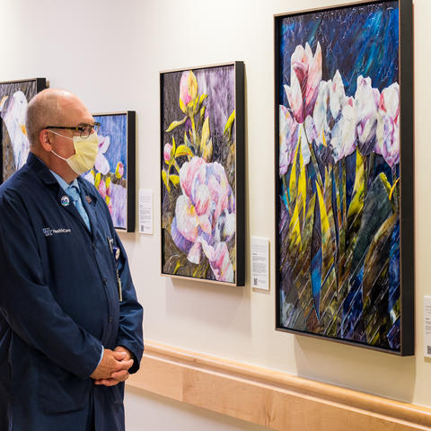 image of man in mask looking at flower painting