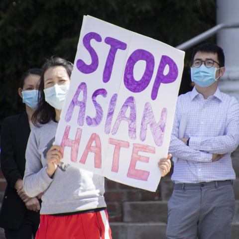 photo of rally organizer Tracy Lu with sign that says "Stop Asian Hate"
