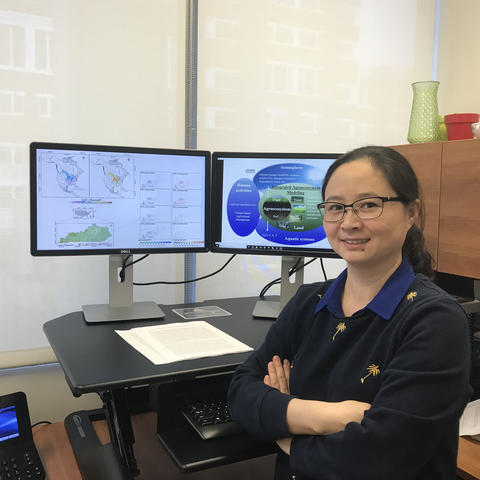 Wei Ren pictured with monitors in office