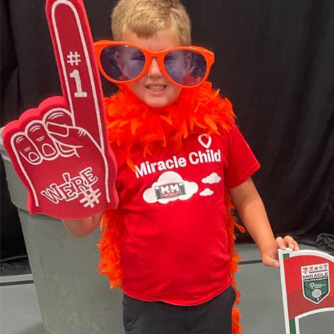 Image of child in red t-shirt with red novelty foam finger