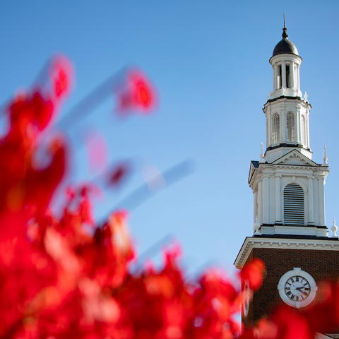 photo of Memorial Hall spire with bright red fall leaves in the foreground