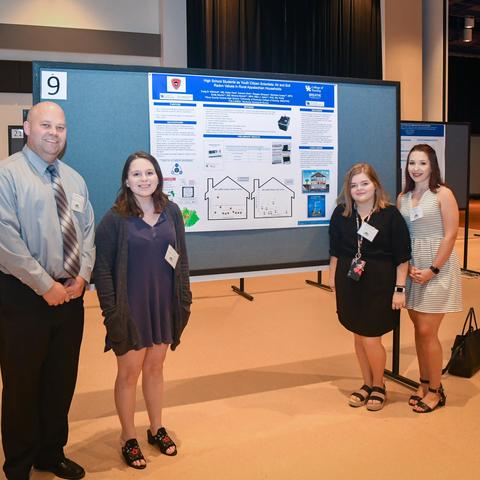 photo of teacher and students presenting research