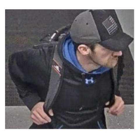 photo of suspect - white man in cap with backpack